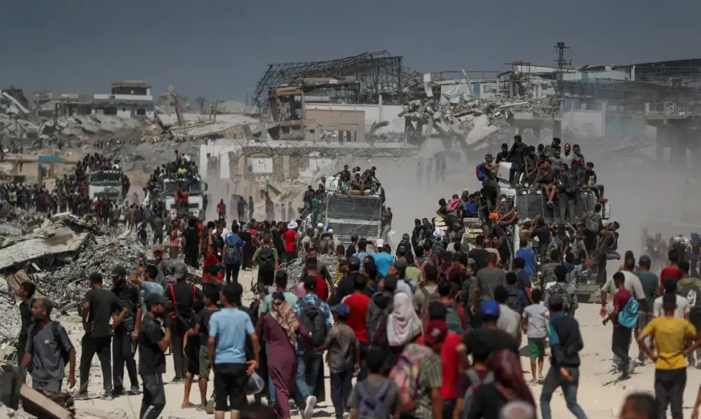 Palestinos carregam ajuda humanitária em Beit Lahia, no norte de Gaza (Foto – Mahmoud Issa/Reuters)